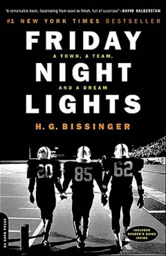 three football players on a field at night