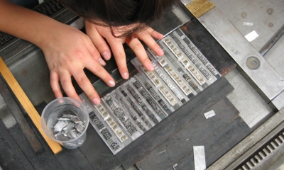 Photo from overhead of student arranging type in letterpress workshop