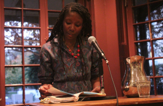 Nicole Dennis-Benn reads intently from her debut novel, Here Comes the Sun