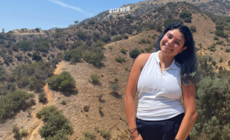 Paola Camacho poses in front of the "Hollywood" sign in Los Angeles