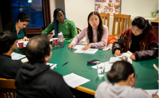 Six students sit around a seminar table at Kelly Writers House discussing the work of James Baldwin