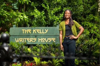 Deborah Olatunji poses next to the Kelly Writers House sign