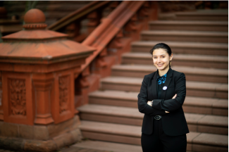 Photo of Rowana Miller standing in front of the Fisher Fine Arts Library staircase