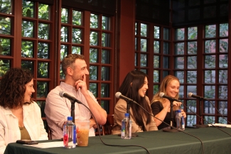 A panel of alumni journalists smiles and laughs at Kelly Writers House