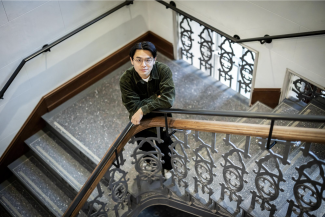 Photograph of Connor Nakamura standing in a campus stairwell